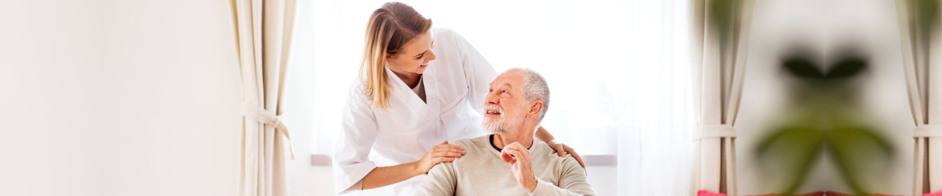 caregiver assisting an elderly man